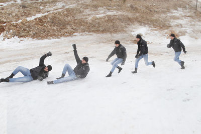 Multiple image of man sliding on snow covered field