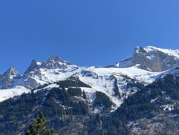 Scenic view of snowcapped mountains against clear blue sky