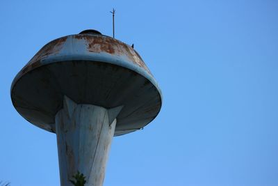 Low angle view of water tower against clear blue sky