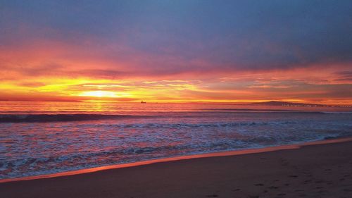 Scenic view of sea against romantic sky at sunset