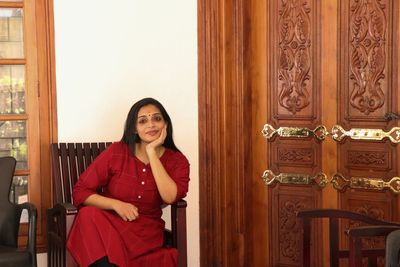 Portrait of young woman sitting near a door