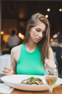 Young woman having food at restaurant