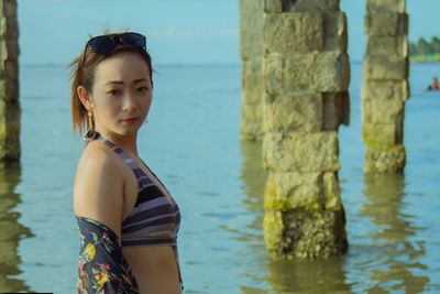 Portrait of woman standing against sea