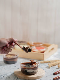 Cropped image of person having chocolate dessert cup