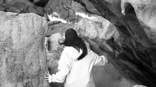 Rear view of woman standing rocks