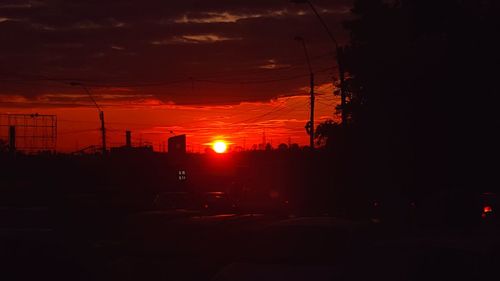 Silhouette city against orange sky