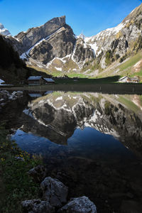 Scenic view of lake by mountains against sky