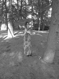 Portrait of a smiling woman standing by tree