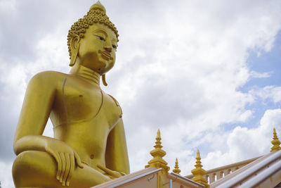 Low angle view of statue against temple against sky