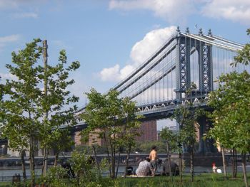 People on bridge against sky