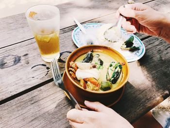 High angle view of hand holding drink on table