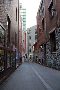 Road amidst buildings in city against clear sky