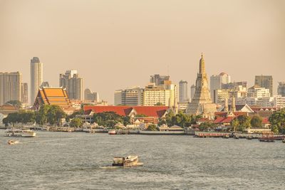 The wat arun buddhist temple in bangkok thailand and the chao phraya river at sunset