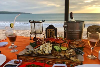 Food on table by sea against sky