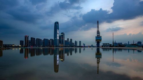 Reflection of buildings in city against sky