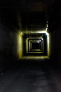 Empty corridor in illuminated tunnel