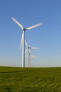 Windmill on field against clear sky