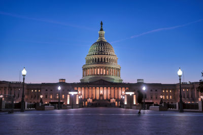 View of illuminated building against blue sky at dusk