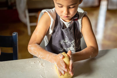 Close up of child hands kneading the dough