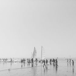 People on beach against clear sky