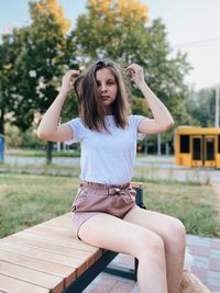 Full length of a young woman sitting outdoors