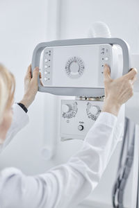 Doctor controlling x-ray machine in clinic