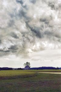 Scenic view of field against cloudy sky