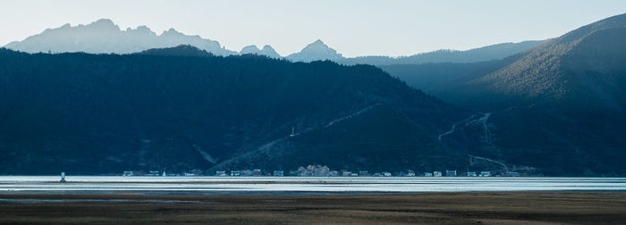 Scenic view of sea and mountains against sky