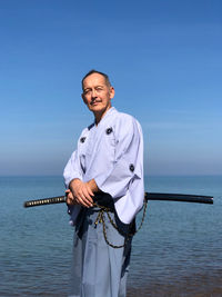 Man with samurai sword standing on beach