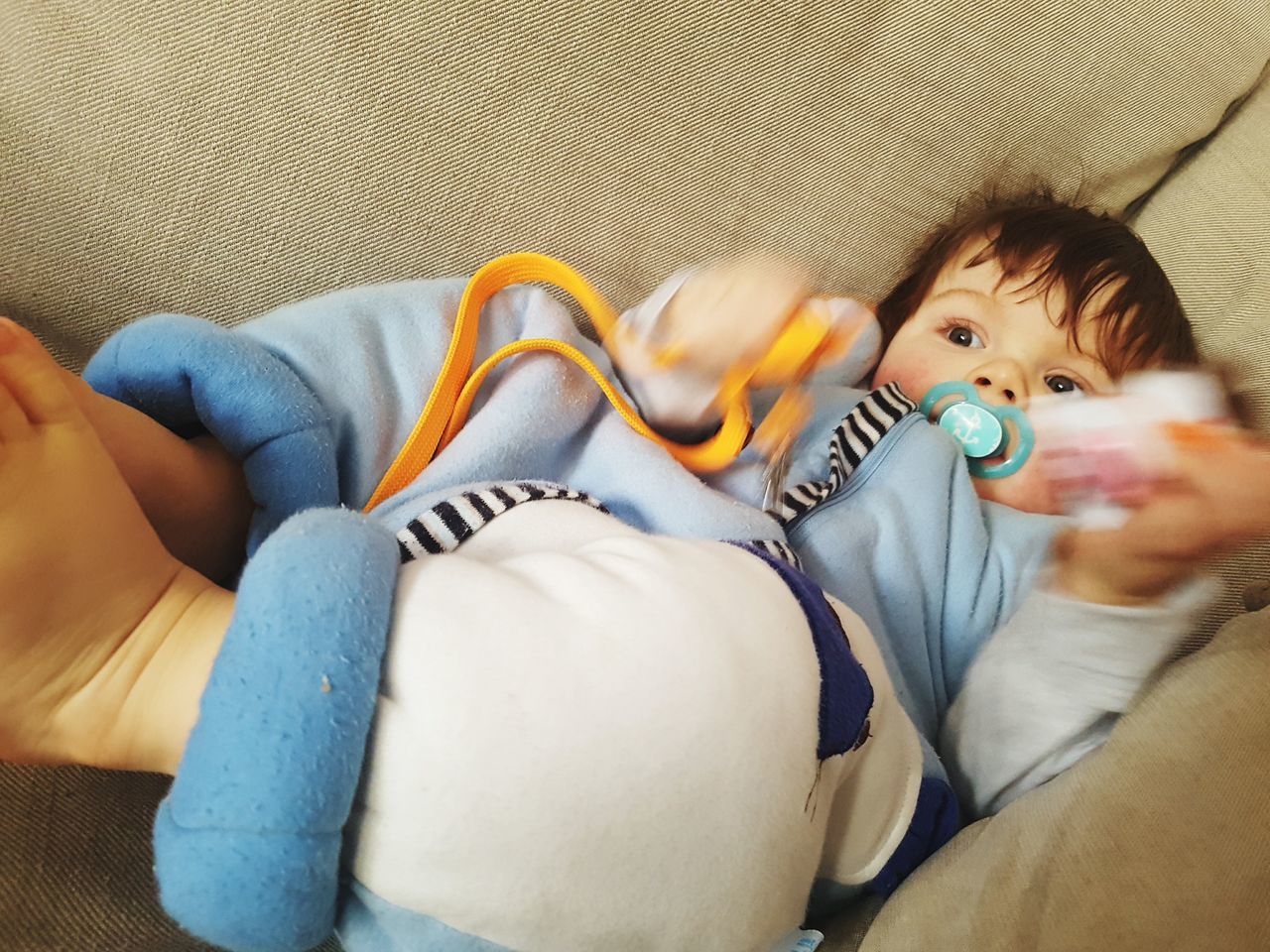 HIGH ANGLE VIEW OF BOY LYING ON SOFA