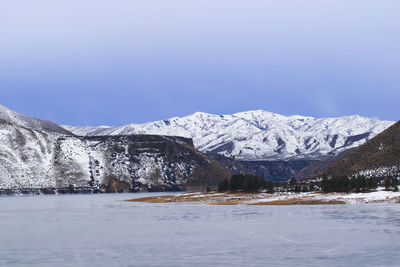 Scenic view of snowcapped mountains against clear blue sky