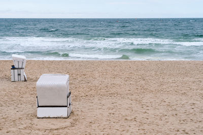 Lounge chairs on beach against sky