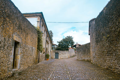 Footpath amidst old ruins against sky