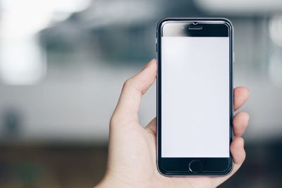 Cropped hand of person holding smart phone