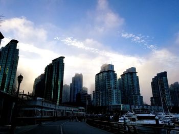 View of skyscrapers in city against cloudy sky