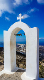 Archway by sea against blue sky