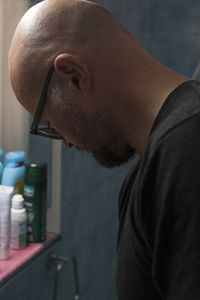 Side view of bald mid adult man in bathroom