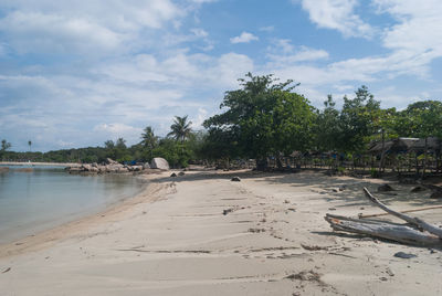 Scenic view of beach against cloudy sky