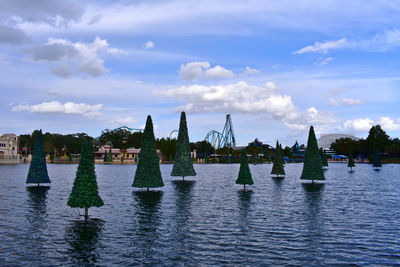 Sailboats in river against sky