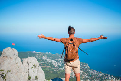 Rear view of people standing by sea against sky