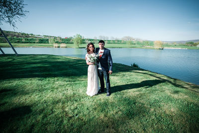 Full length of happy woman standing in lake