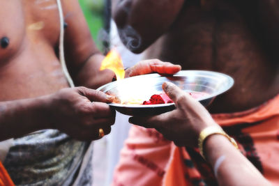 Midsection of people having food in plate