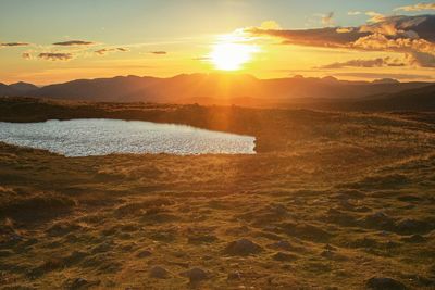 Scenic view of lake against sky during sunset