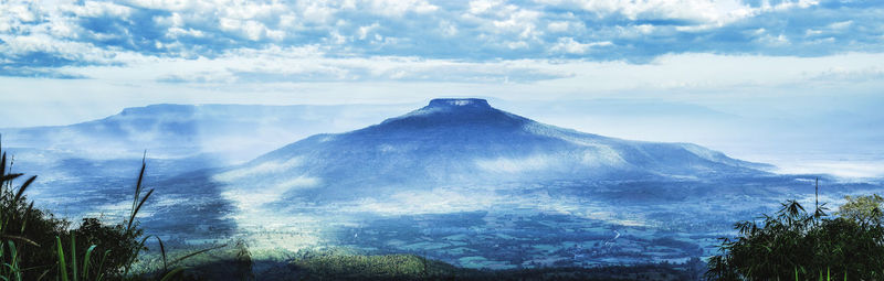 Volcanic mountain against cloudy sky