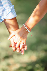 Couple hold hands in a vineyard at sunset