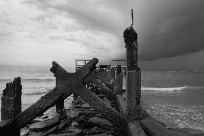 Abandoned built structure on beach against sky