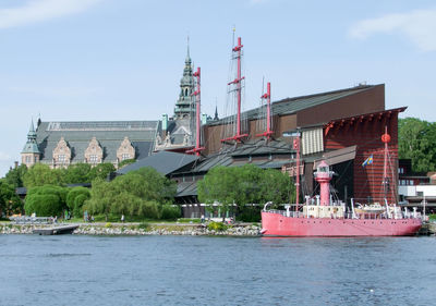 Traditional building by river against sky