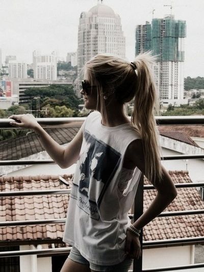 building exterior, young adult, architecture, young women, built structure, lifestyles, city, long hair, waist up, leisure activity, sculpture, standing, person, day, three quarter length, casual clothing, focus on foreground