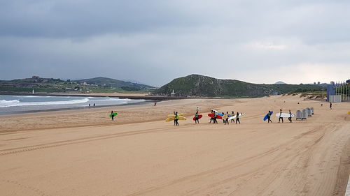 People on beach against sky