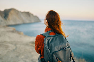 Rear view of woman looking at sea against sky